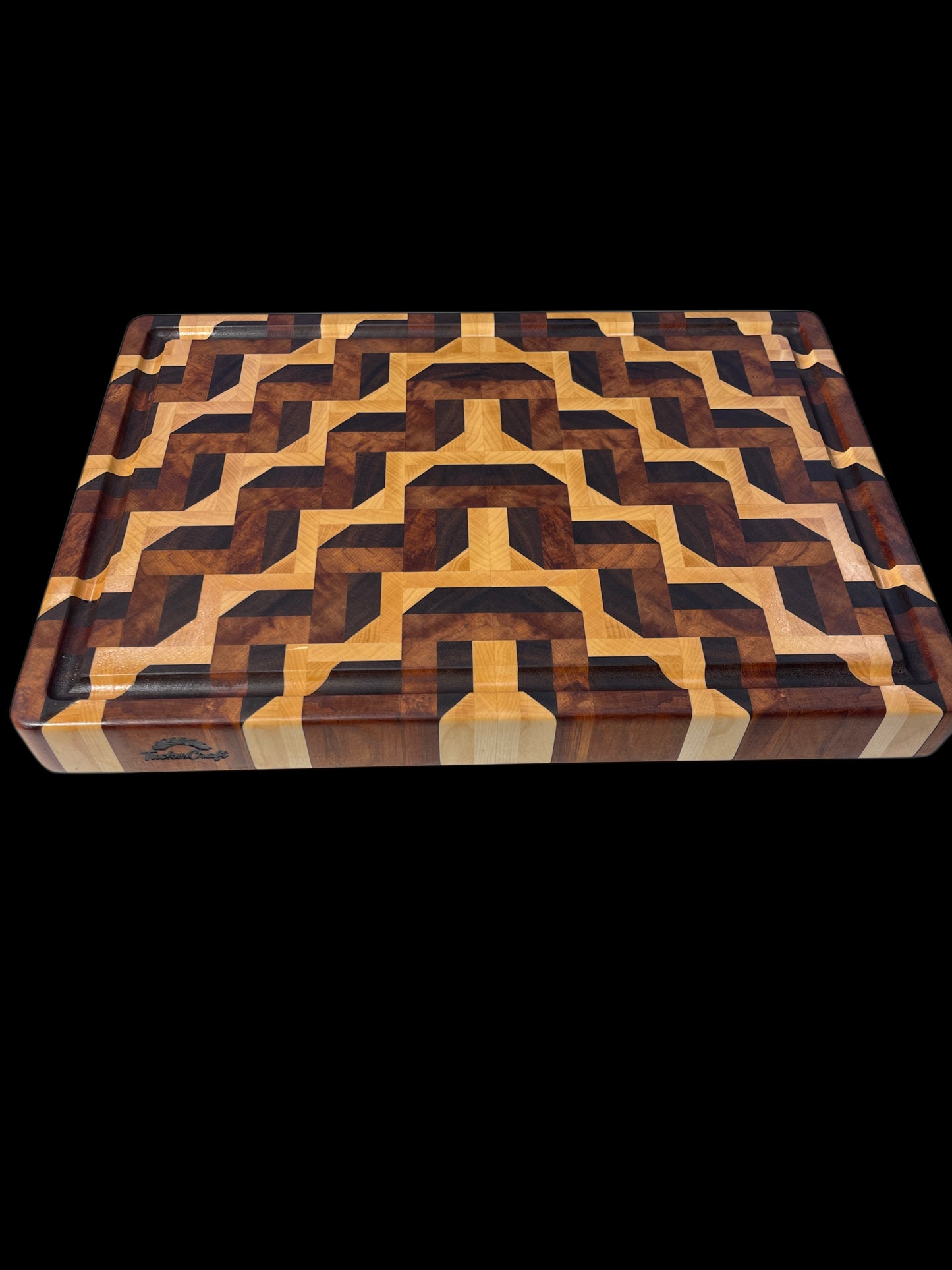The Paradox Board by Tuckercraft, a handcrafted Luxury end-grain chopping board made in New Zealand from Walnut, Maple and reclaimed Herat Rimu featuring an intricate geometric pattern and juice groove.
 